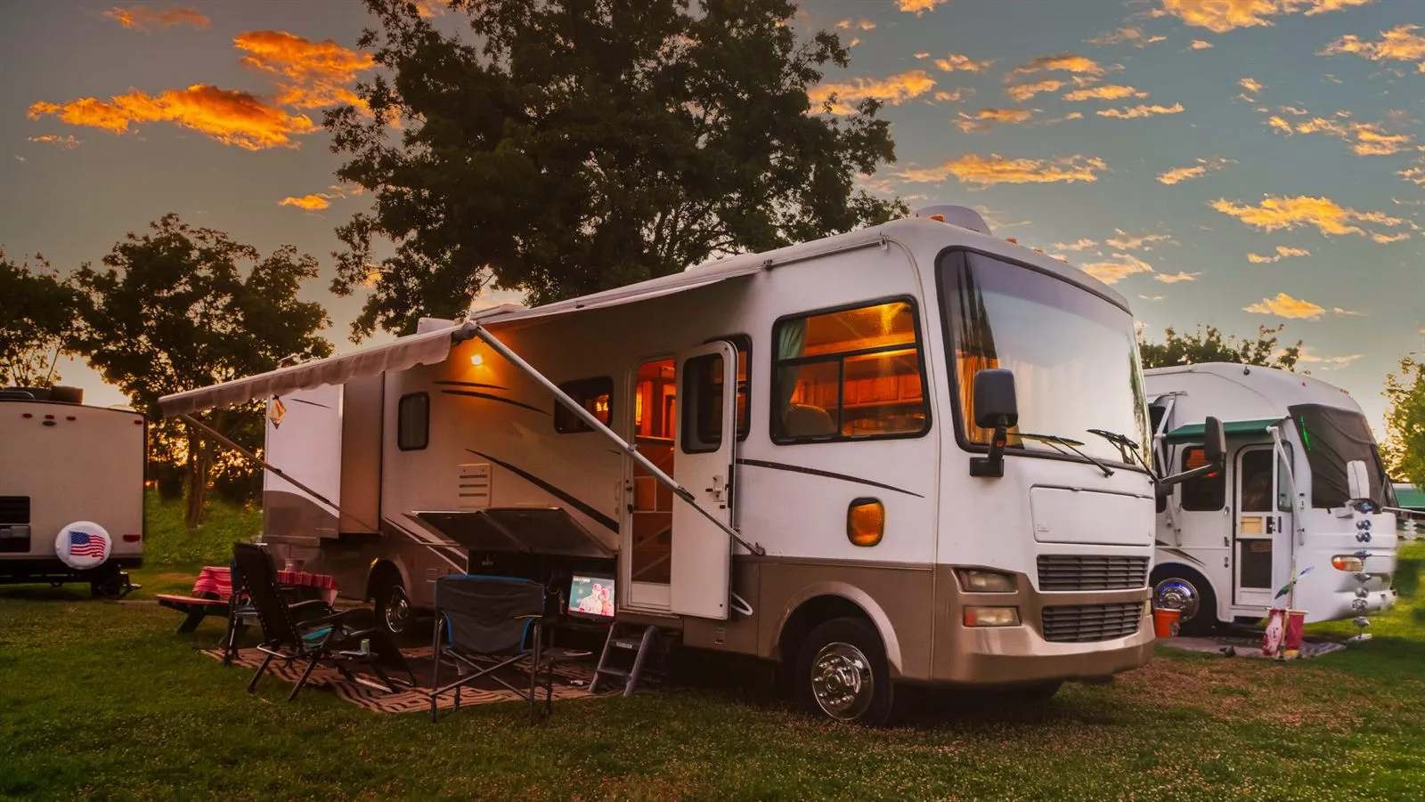 Class A motorhome with its awning out at golden hour in an East Texas RV park